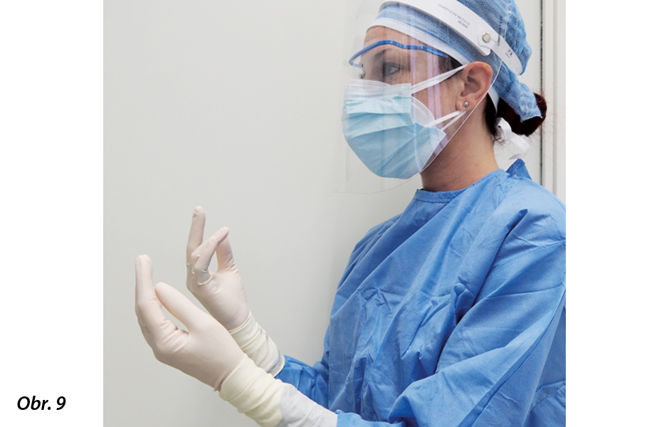 První člen týmu připravuje čisté operační podmínky: oblékne si jednorázový plášť a poté si nasadí sterilní rukavice.